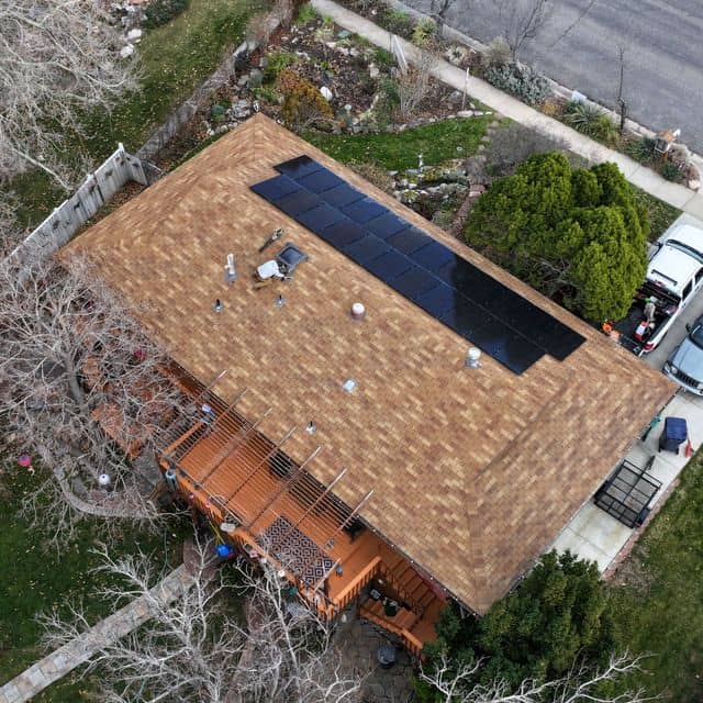 Asphalt shingle roof with solar panels before restoration treatment.