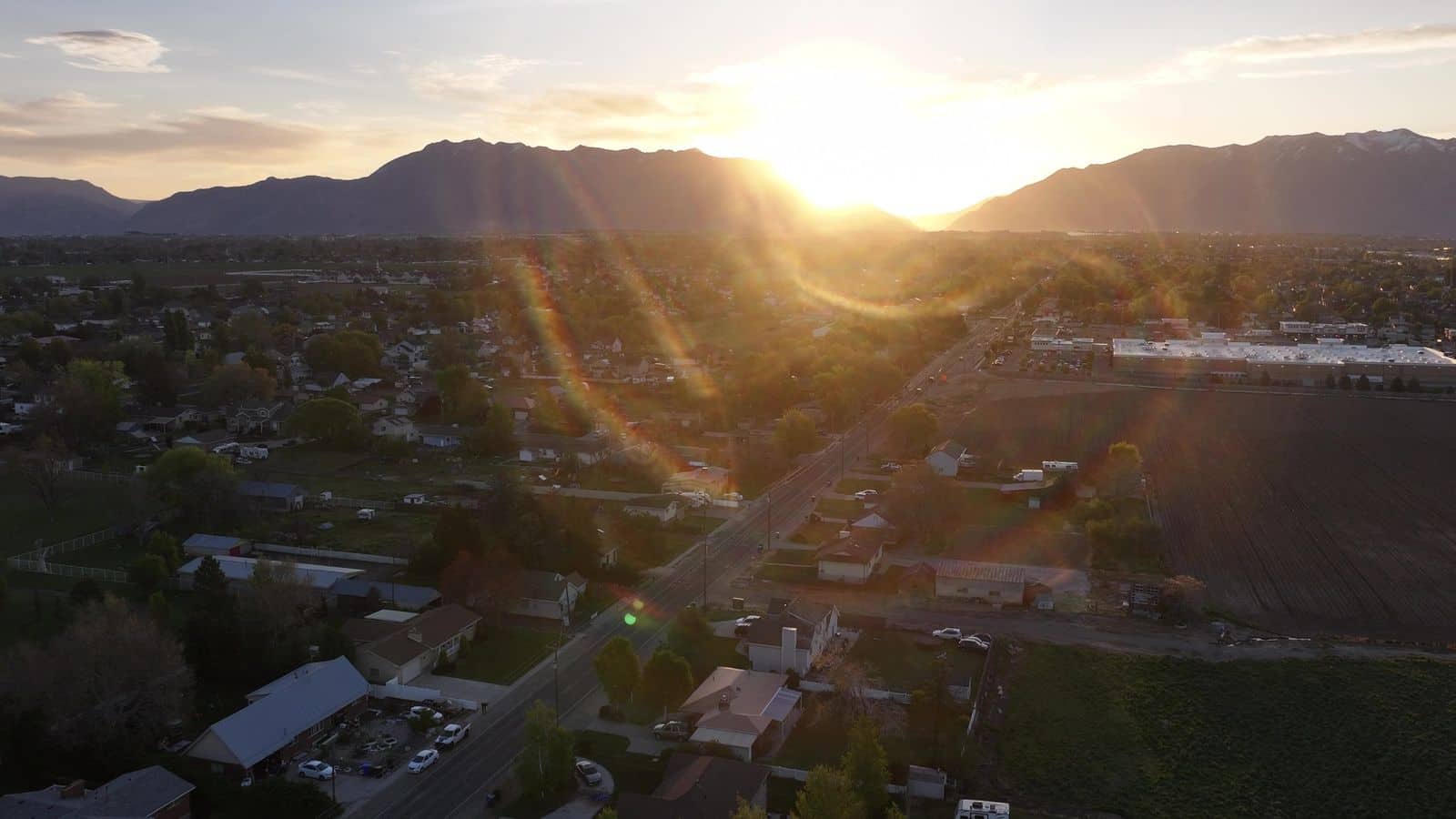 Golden sunrise over the Wasatch and a valley neighborhood. The NuRoof Guys.