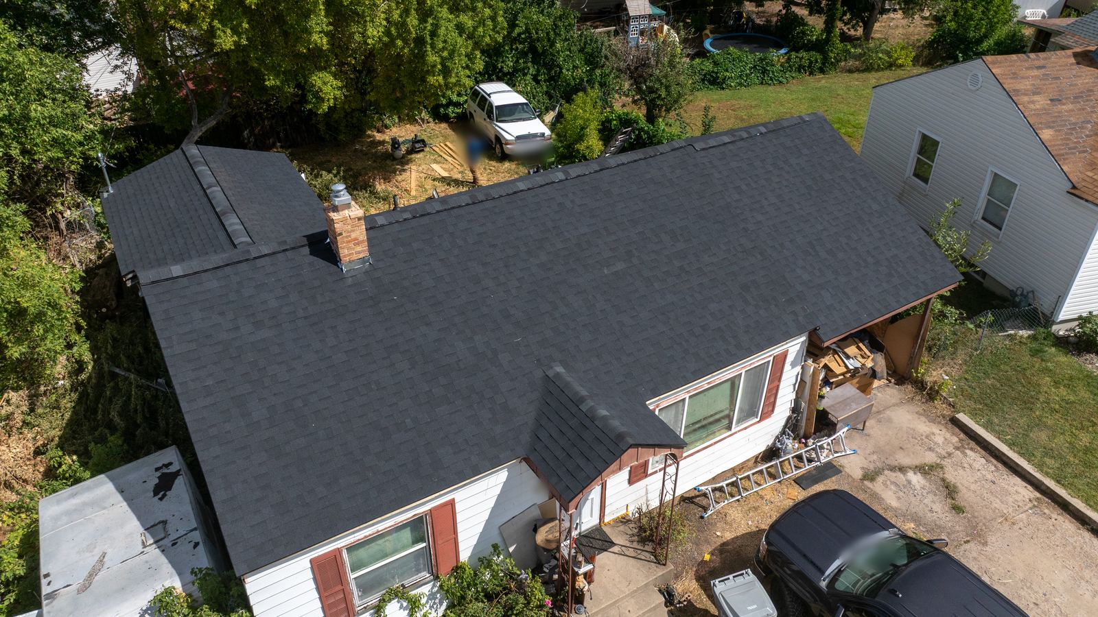 Finished dark asphalt shingle roof with even courses and clean ridge lines, the kind of well-kept roof that makes insurance conversations easier. The NuRoof Guys.