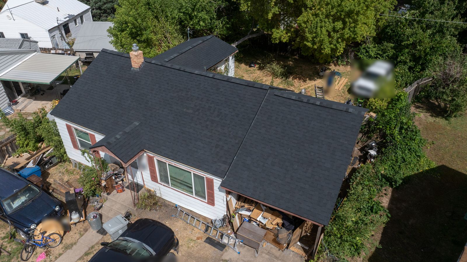 Aerial view of a finished dark asphalt shingle roof on a Utah home