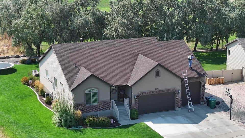 Aerial view of a home with a brown shingle roof in summer. The NuRoof Guys.