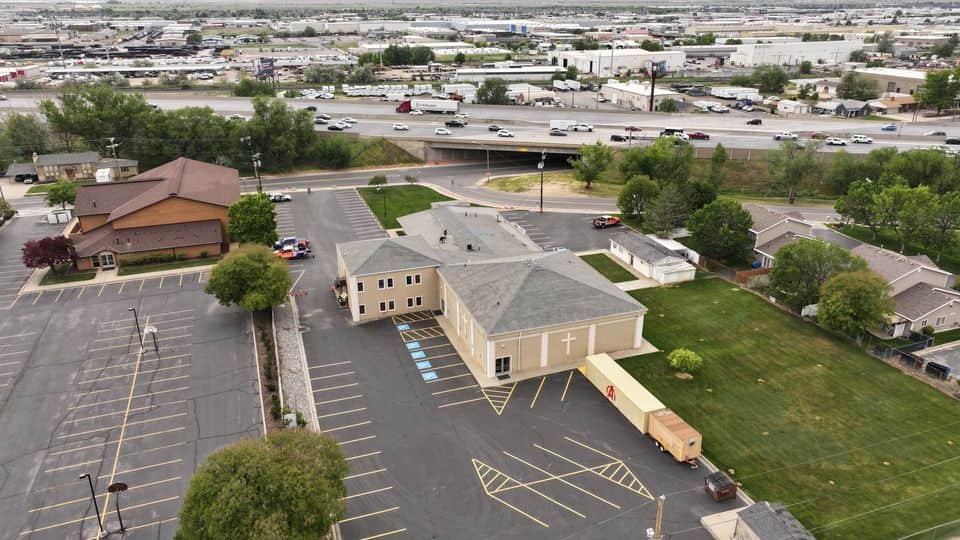 Aerial view of a commercial building with a shingle roof. The NuRoof Guys.