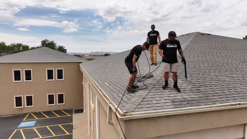 Three technicians working on the roof of a commercial building. The NuRoof Guys.