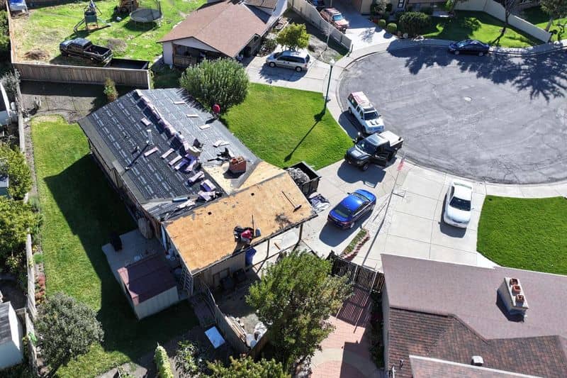Bundles of new asphalt shingles staged on a roof during replacement.