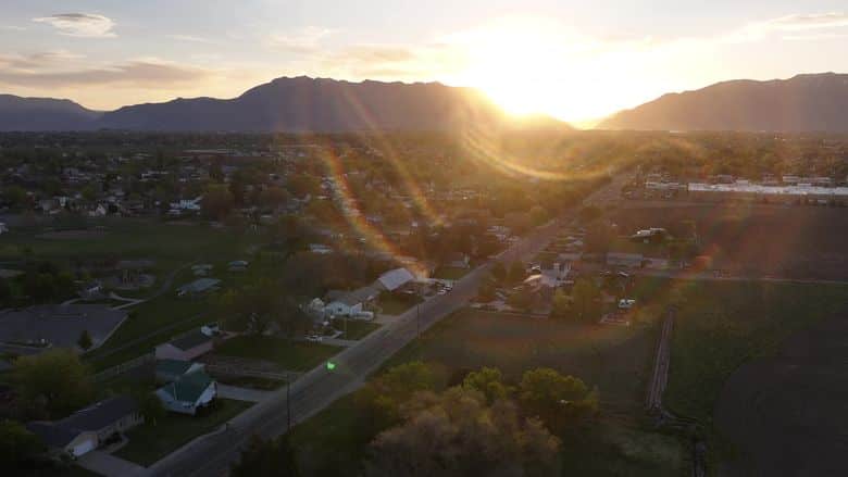 Golden sunrise over the Wasatch and a valley neighborhood. The NuRoof Guys.