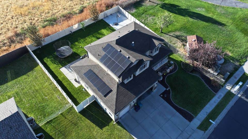 Top-down aerial view of a home with solar panels. The NuRoof Guys.