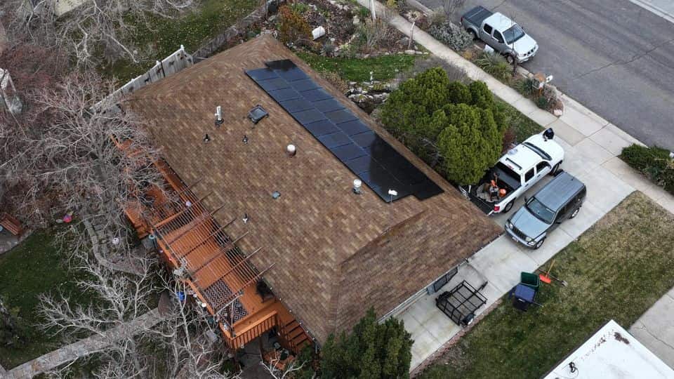 The same brown asphalt shingle roof with solar panels after restoration treatment.