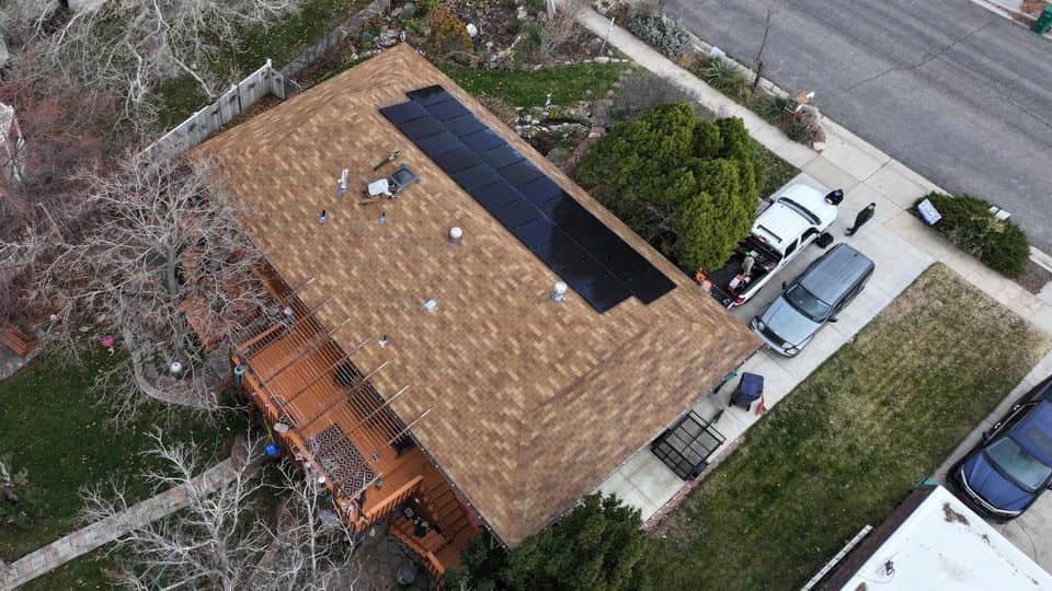 Brown asphalt shingle roof with solar panels before restoration treatment.