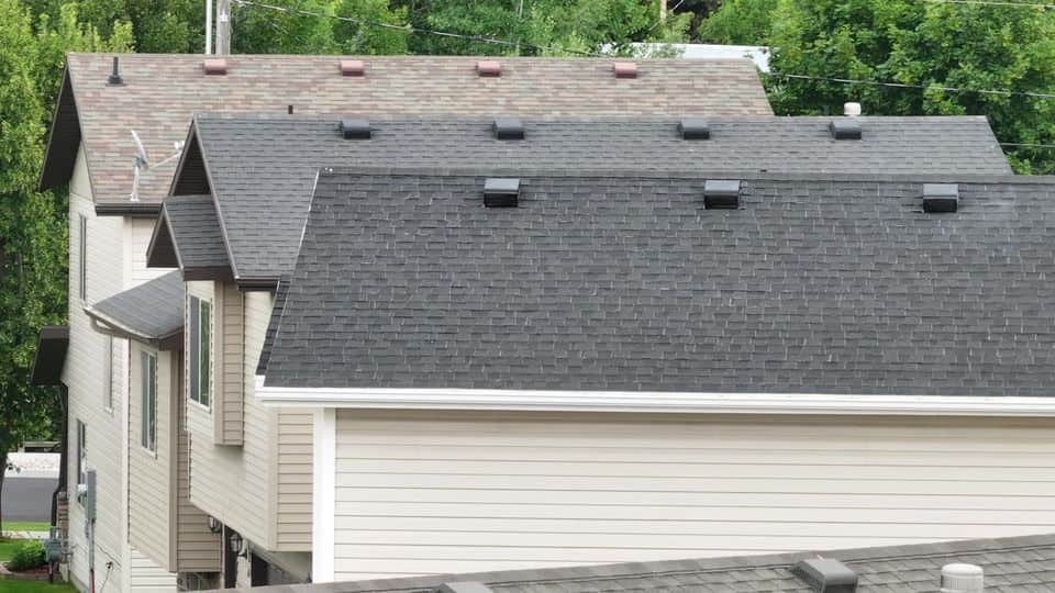 The same two-story Logan home after restoration, with a darker front roof.