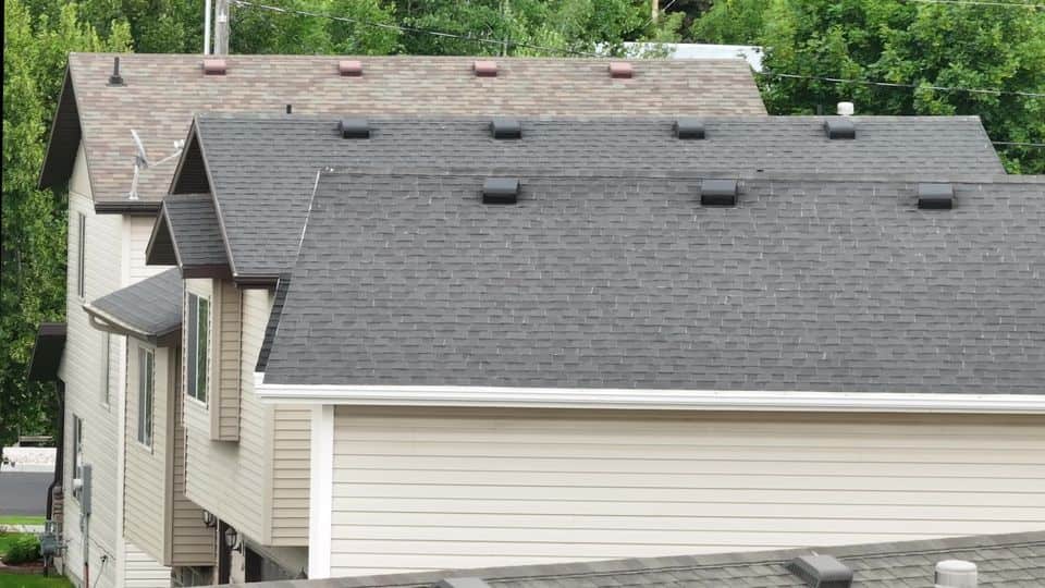 Two-story home in Logan with a gray-brown asphalt shingle roof before restoration.