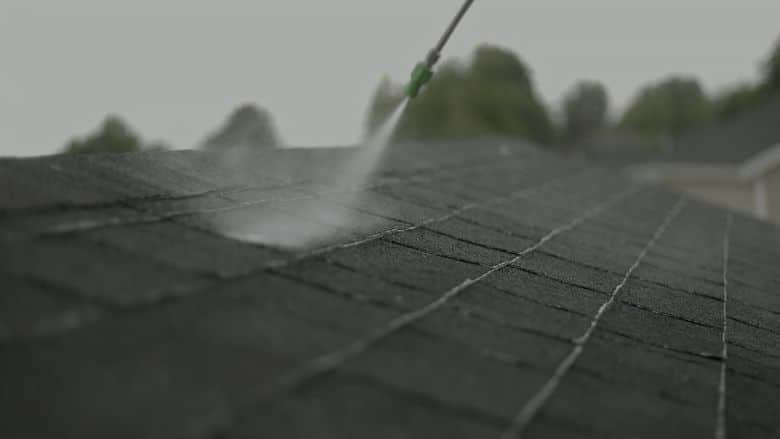Slow-motion spray mist across shingles. The NuRoof Guys.